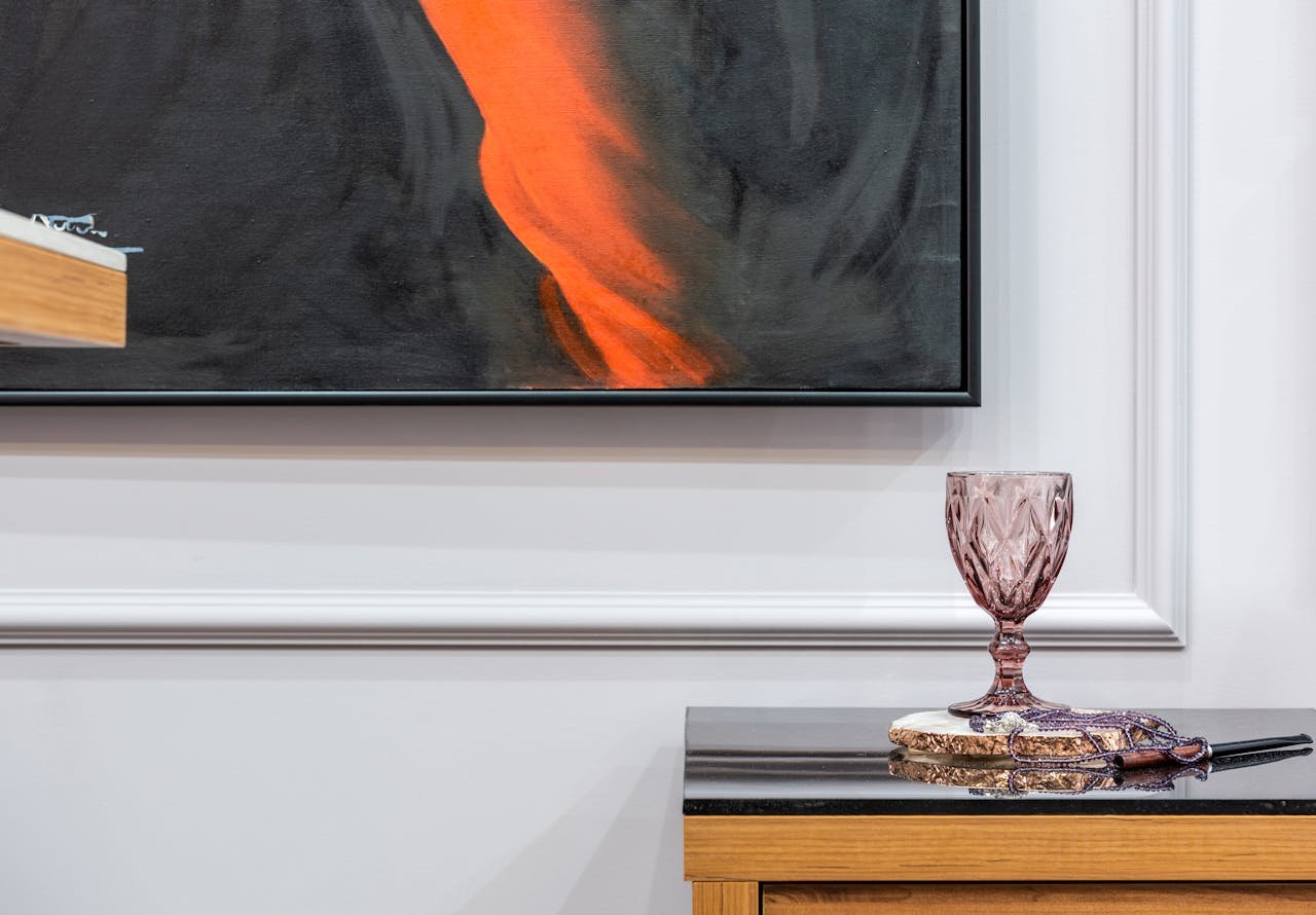 Abstract painting with decorative glass on wooden table, perfect for modern home decor inspiration.